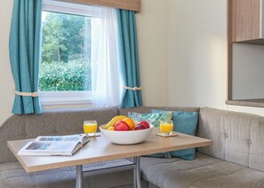 A cozy corner with a table, a bowl of fruit, and two glasses of orange juice. - Standard 2 Bedroom sleeps 6 Pet Friendly (Hayle)