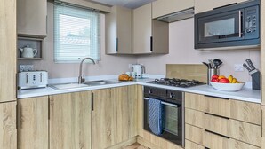 Uma cozinha moderna com forno embutido, micro-ondas e torradeira.