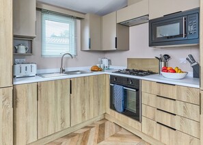 A modern kitchen with a built-in oven, microwave, and toaster. - Superior 2 Bedroom sleeps 6 (Hayle)