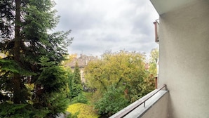 Een balkon met uitzicht op een tuin en huizen.
