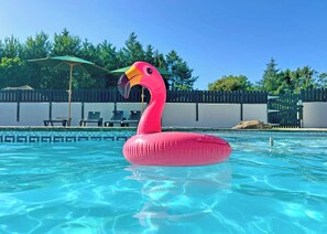 Een zwembad met een roze flamingo drijver.