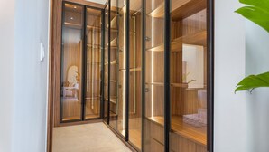 Ein begehbarer Kleiderschrank mit mehreren Holzböden und einem Spiegelbereich.