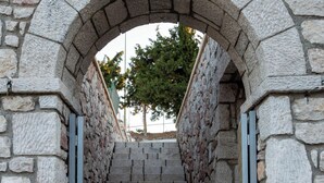 Uma escadaria de pedra com um arco de pedra, que sobe.