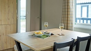 Ein Esstisch mit zwei Weingläsern, einer Schüssel Essen und einer Zeitschrift.