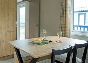 A dining table with two wine glasses, a bowl of food, and a magazine. - Luxury 3 bedroom Hot Tub sleeps 8 (Hayle)
