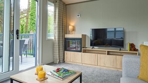 Ein modernes Wohnzimmer mit Fernseher, Sofa und Couchtisch.