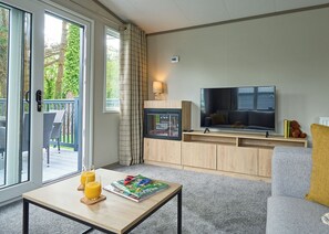 A modern living room with a TV, sofa, and coffee table. - Luxury 3 bedroom Hot Tub sleeps 8 (Hayle)