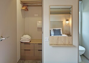 A bathroom with a mirror, a towel rack, a toilet, and a wooden cabinet. - Luxury 3 bedroom Hot Tub sleeps 8 (Hayle)