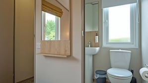 Ein Badezimmer mit Toilette, Waschbecken und Fenster.