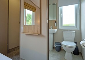 A bathroom with a toilet, sink, and window. - Luxury 3 bedroom Hot Tub sleeps 8 (Hayle)
