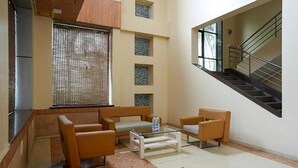 A modern living room with a sofa set, a coffee table, and a staircase. - Rester Select Chakan (Rajgurunagar)