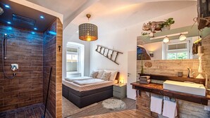 Een moderne badkamer met een douche, een bad, een grote spiegel en een wastafelmeubel met een wastafel.