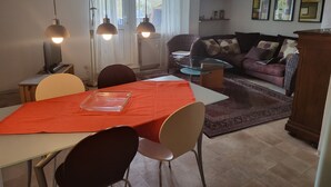 A dining area with a table set for two, a sofa, and a coffee table in the background. - Cozy garden apartment near Herrsching (Herrsching am Ammersee)
