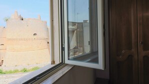 Ein Fenster mit Blick auf einen historischen Steinturm.
