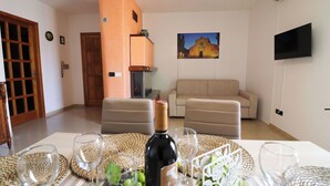 Ein Wohnzimmer mit einem beigen Sofa, einer Holztür, einem Kamin und einem Bild an der Wand.