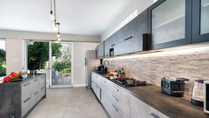A modern kitchen with a large island, built-in appliances, and a stone backsplash. - Sorrento Sea View Villa - 4BR, Panoramic Terraces & Private Parking (Priora)