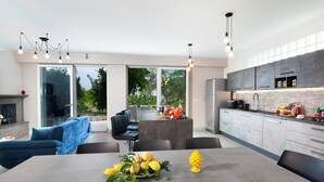 A modern kitchen with a dining area, large windows, and a fireplace. - Sorrento Sea View Villa - 4BR, Panoramic Terraces & Private Parking (Priora)