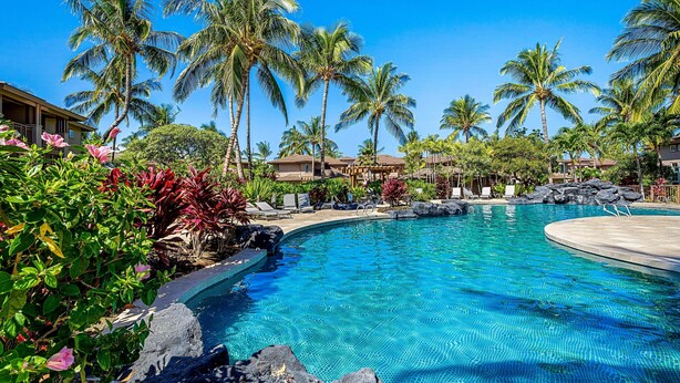 A resort pool with clear blue water, surrounded by palm trees and tropical plants. - 3BR Golf Course View Condo Waikoloa Colony Villas #805 - Vrkcv (Waikoloa)