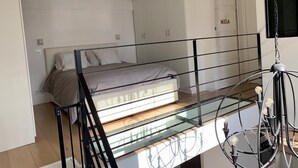 Ein gemütliches Schlafzimmer mit Etagenbett, Glastisch und Metalllüster.
