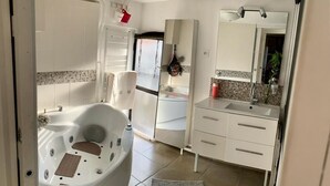 Ein modernes Badezimmer mit einer großen Badewanne, einem Waschbecken mit Spiegel und einem Waschbecken.
