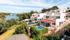 Une villa moderne dotée d’une piscine, de plusieurs balcons et offrant une vue sur la mer.