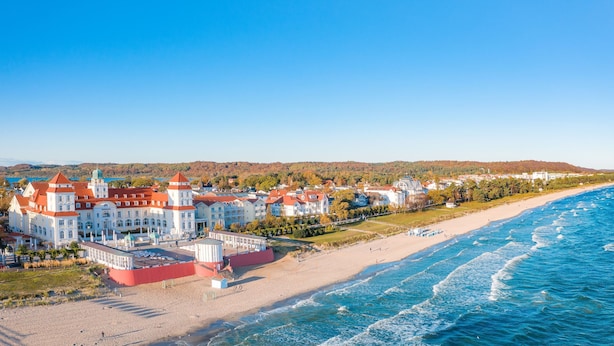 A coastal town with a prominent white building with red roofs, a beach, and a view of the sea. - Villa Schlossallee Rügen - thatch on the golf course. Sauna. Sea view. (Lohme)