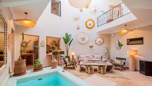 A spacious living area with a pool, a dining set, and a staircase leading to an upper level. - Riad Privé 4 Suites avec Piscine Chauffée, Rooftop & Vue Atlas – Médina (Marrakesh)