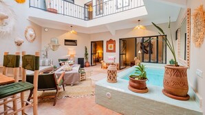 A spacious indoor area with a pool, seating, and a balcony. - Riad Privé 4 Suites avec Piscine Chauffée, Rooftop & Vue Atlas – Médina (Marrakesh)