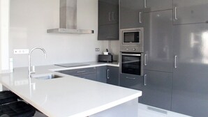 A modern kitchen with a stainless steel range hood, a built-in microwave, and a double oven. - 5 Bed 4 Bath Villa, Private Pool, Modern, All Amenities, Pau26 Villamartin (Orihuela)