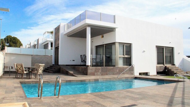 A modern house with a swimming pool, outdoor seating, and a covered patio. - 5 Bed 4 Bath Villa, Private Pool, Modern, All Amenities, Pau26 Villamartin (Orihuela)