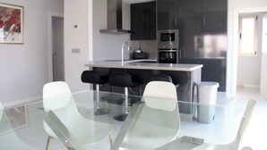 A modern kitchen with dark cabinets, a stainless steel range hood, and a built-in oven. - 5 Bed 4 Bath Villa, Private Pool, Modern, All Amenities, Pau26 Villamartin (Orihuela)