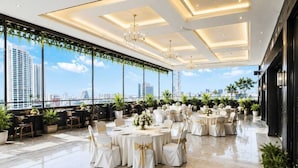 A rooftop venue with round tables, chairs, and potted plants. - Hotel Eco Park by Carlton Suites (Barasat)