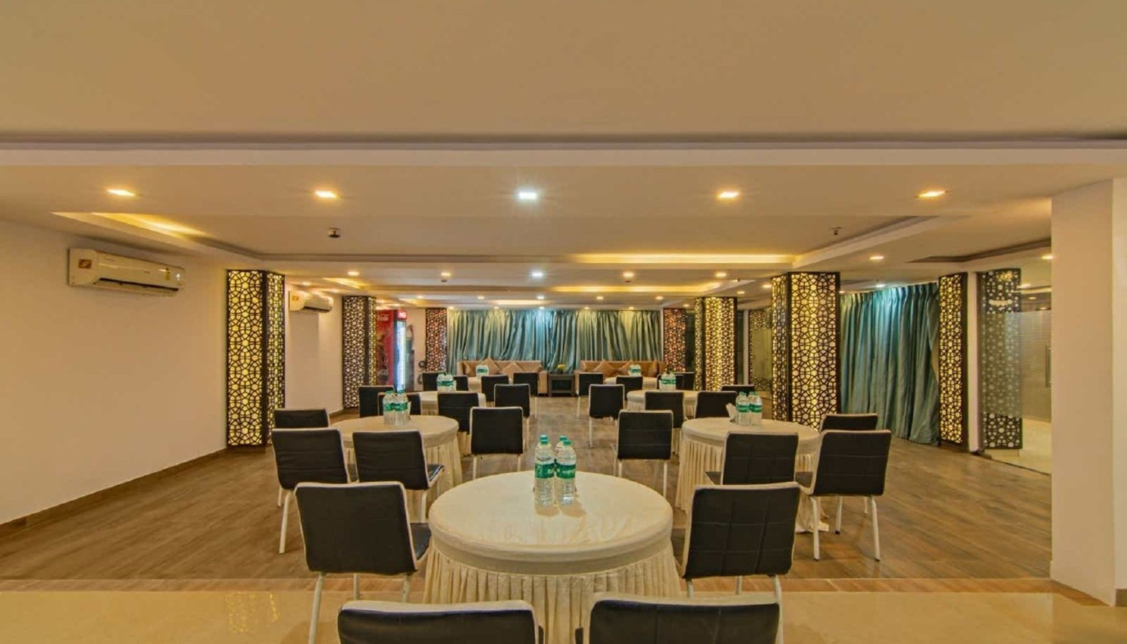 A conference room with round tables, chairs, and decorative panels.