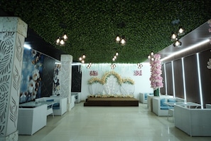 A modern indoor setting with a stage, seating, and decorative elements. - Frolic Hotel Near Sec 52 Noida Metro Station (Noida)