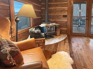A cozy cabin interior with a wooden interior, a fireplace, a leather chair, and a fur rug. - Bear Cove - rustic mountainside cabin with incredible view + free train tix (Bryson City)