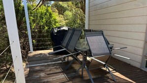 A wooden deck with outdoor furniture, including a table and chairs, and a grill. - 700m to Surf Beach•Relaxed Family Coastal Escape for 5•Linen provided (Venus Bay)