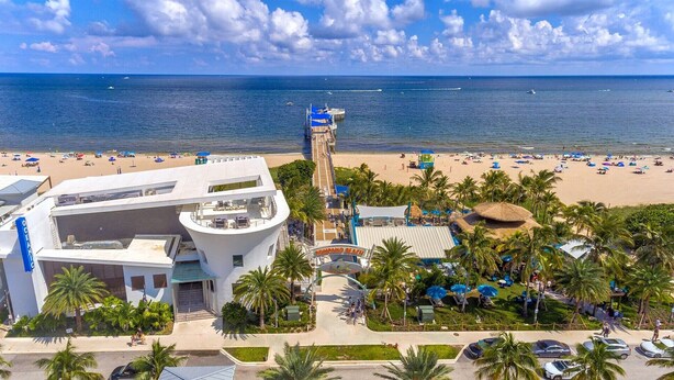 A resort with a beach, a pool, and a view of the ocean. - A boutique, renovated coastal retreat featuring fully equipped condos w/kitchen, minutes walking to the beach & restaurants, exciting amenities like a heated pool, BBQ Grill, hammock and fun yard games. Centrally located, minutes to Pompano Beach! (Pompano Beach)