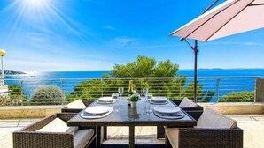 Mesa de comedor al aire libre con vista al mar.