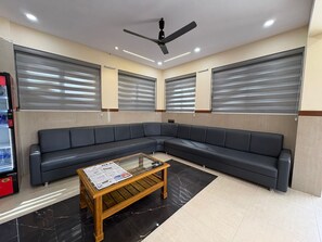 A waiting area with a sofa, a coffee table, and a ceiling fan.