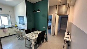 A compact kitchen with a dining area, a window, and a built-in oven. - 2 Bedroom Apartment Marconi Trastevere Station (Roma)