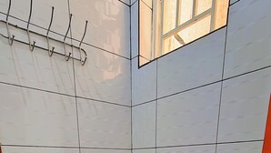 A small, clean bathroom with a toilet, sink, and a towel rack. - Parkviewperch (Kigali)