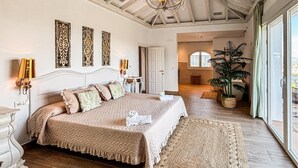 A spacious bedroom with a large bed, a chandelier, and a view of the outdoors. - Awesome home in Coin with private swimming pool, can be inside or outside (Coin)