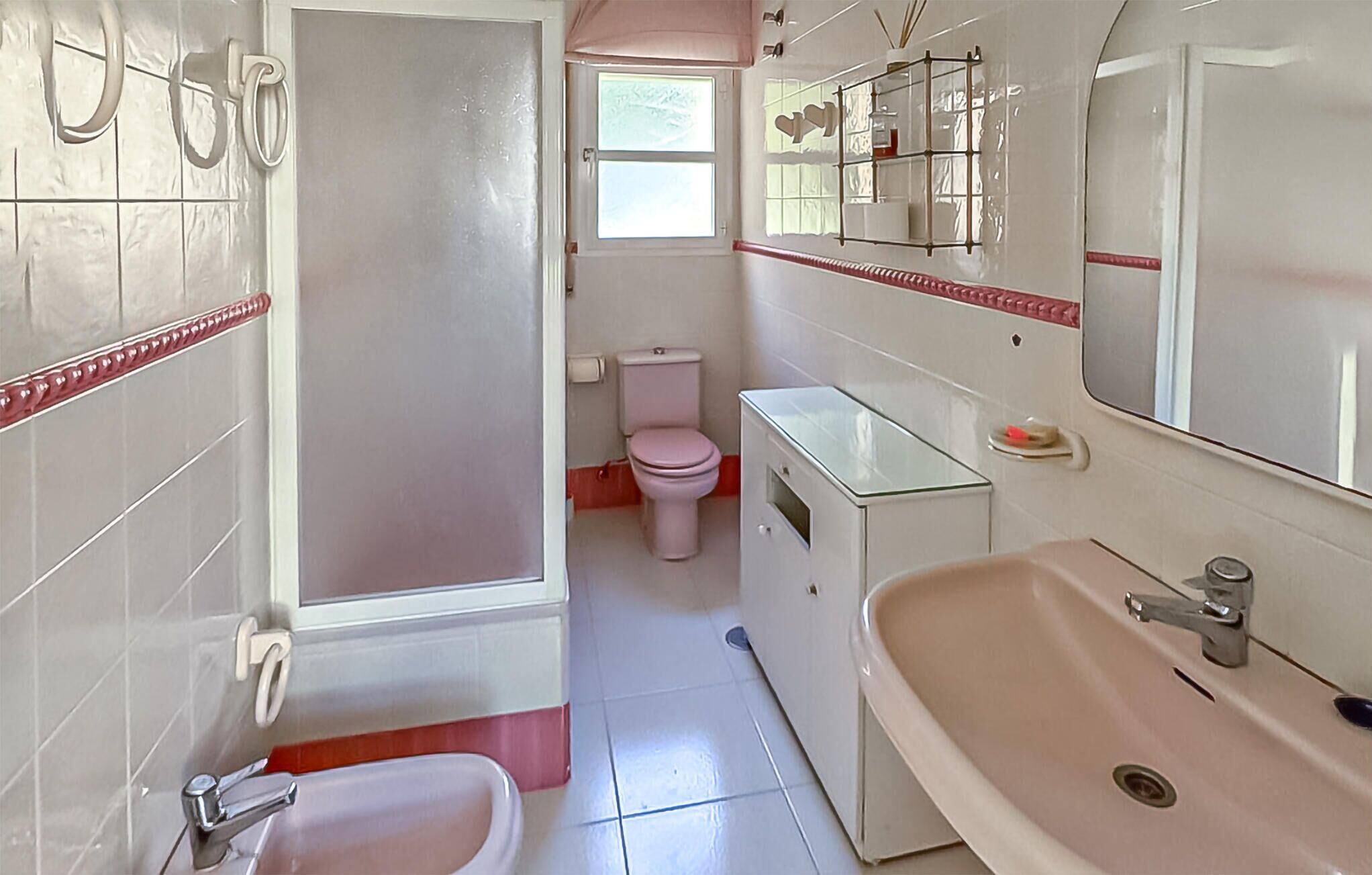 Un bany amb vàter, bidet, rentamig i mirall.