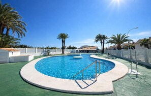 A circular pool with a diving board, surrounded by palm trees and a white fence. - Lovely home in Vera with swimming pool (Vera)