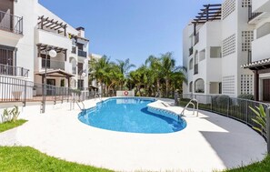 A swimming pool surrounded by a white fence, with a clear blue sky above. - Stunning apartment in Itrabo with WiFi (Itrabo)