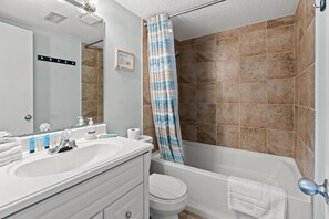 Un bagno completo di doccia, WC, lavandino e specchio.