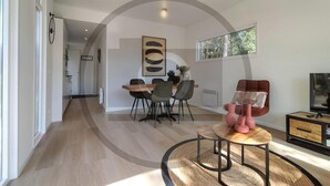 A modern living room with a dining area, a large window, and a television. - Stunning home in Vinkeveen with sauna (Vinkeveen)