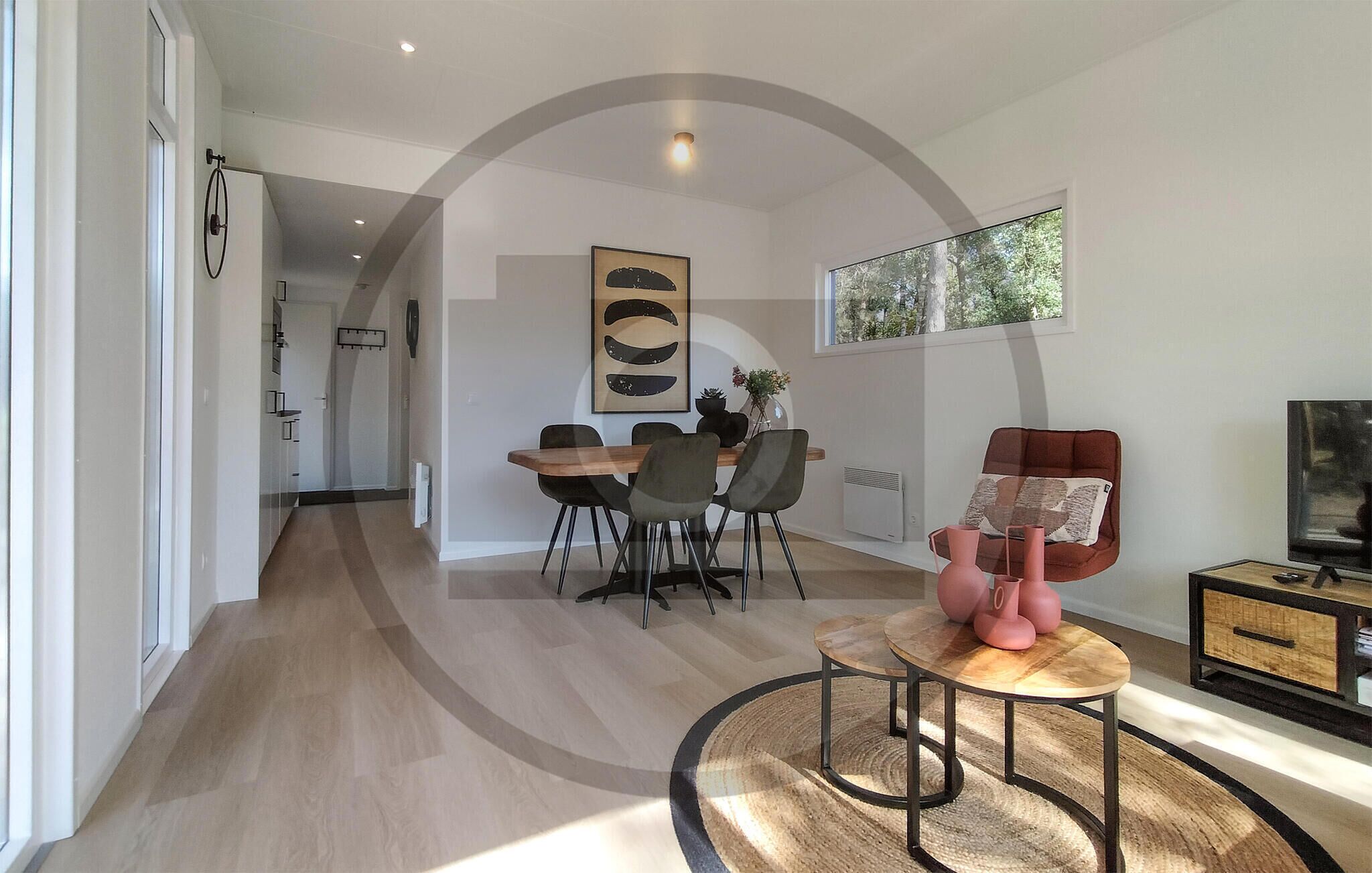 A modern living room with a dining area, a large window, and a television.