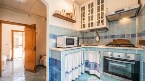 Une cuisine équipée d’un four à micro-ondes, d’une cuisinière, d’un four et de placards.