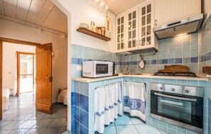 A kitchen with a microwave, stove, oven, and cabinets. - Beautiful home in Stintino with WiFi (Stintino)